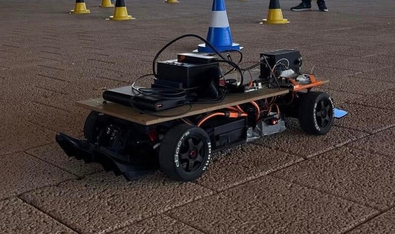 Small-scale electric racing car on a course marked with cones